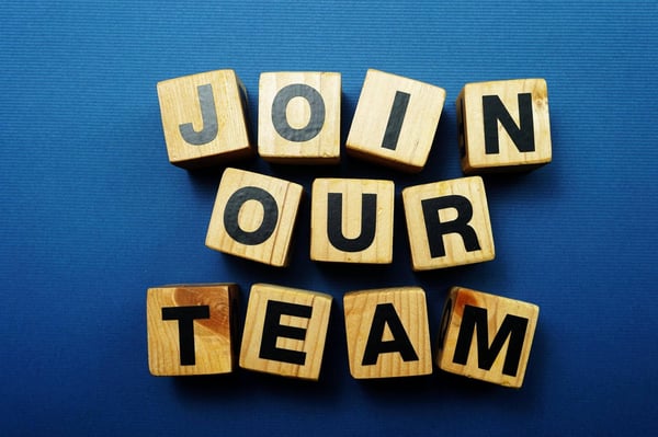 Wooden blocks that say Join Our Team on a blue background