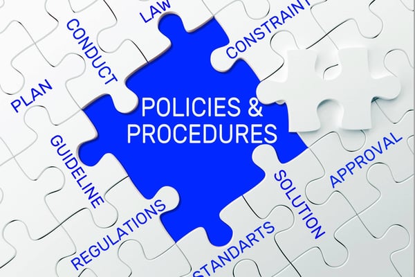 Puzzle that contains words associated with company policies with the words policies & procedures on the central piece