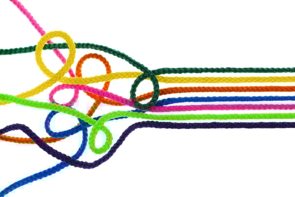 An unorganized tangle of multi-colored string becomes braided into one cohesive strand to represent the way using DocuWare for business information management organizes information to maximize its usefulness