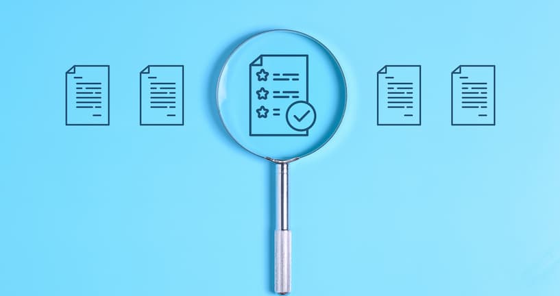 Magnifying glass over paper icon for business documents