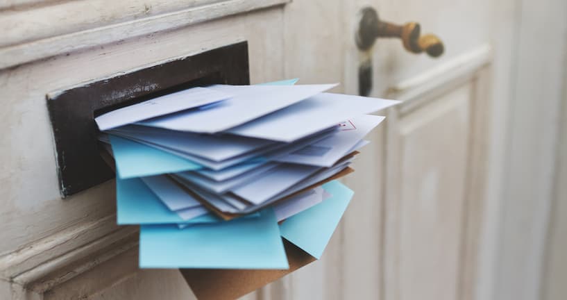 Mit Briefen vollgestopfter Briefschlitz