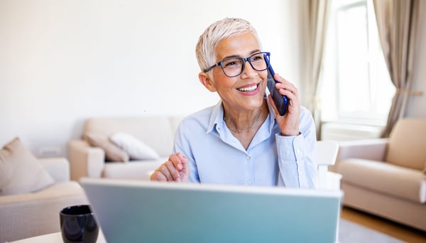 Happy older woman at desk with computer (1)