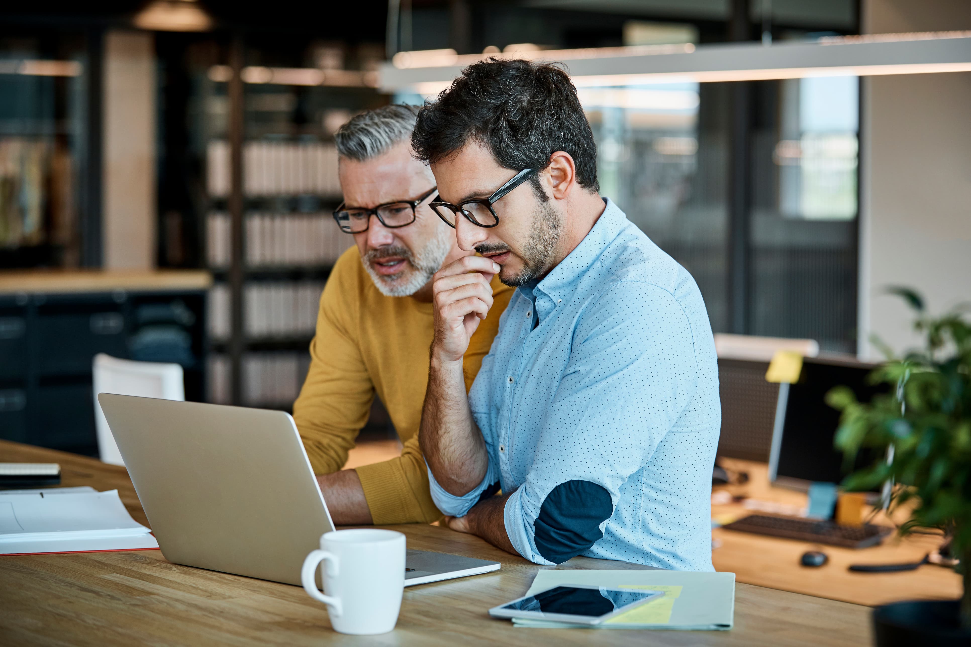 Two businessmen sitting at a laptop