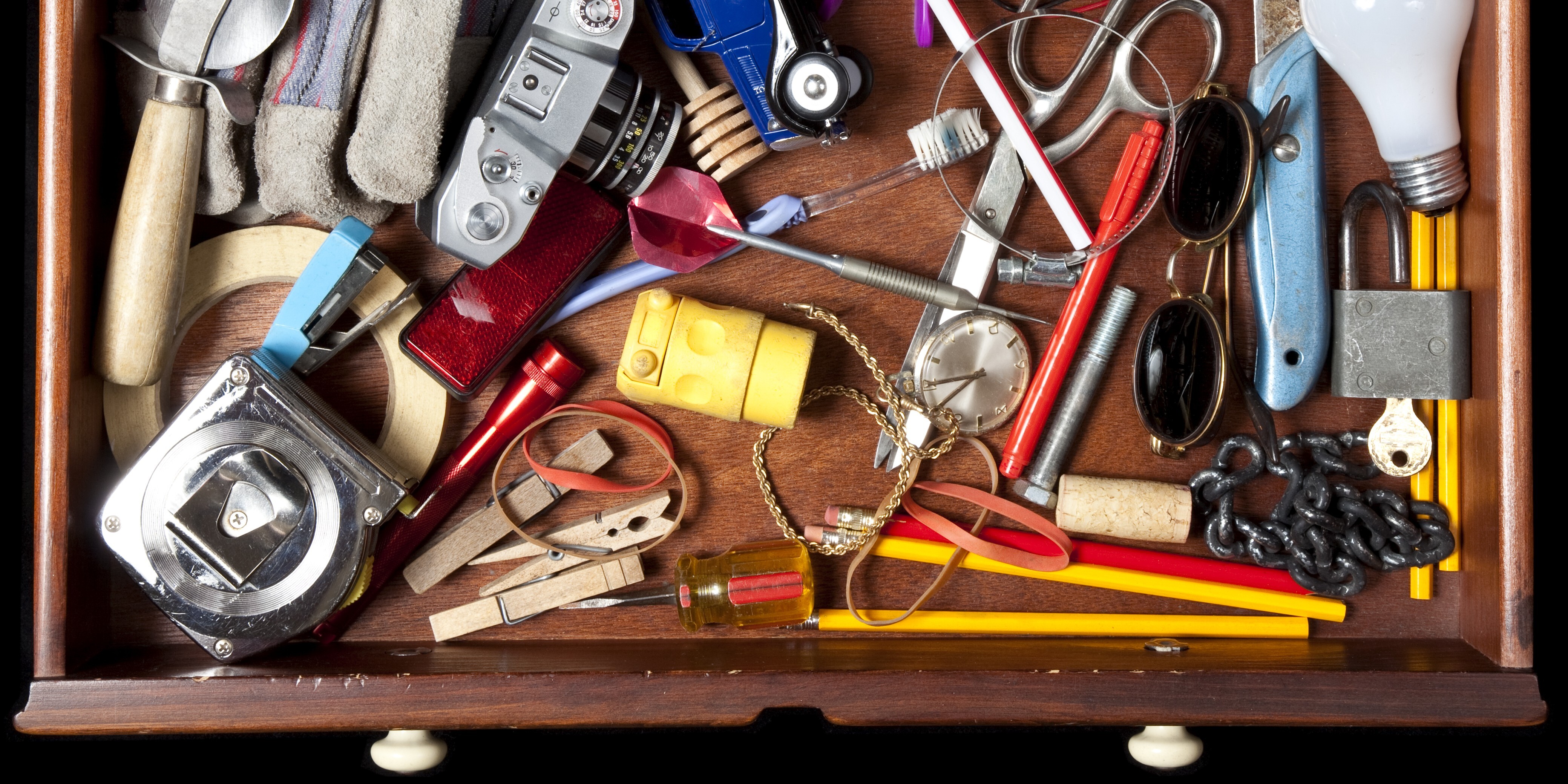 Contents of a junk drawer holding a variety of unrelated items.