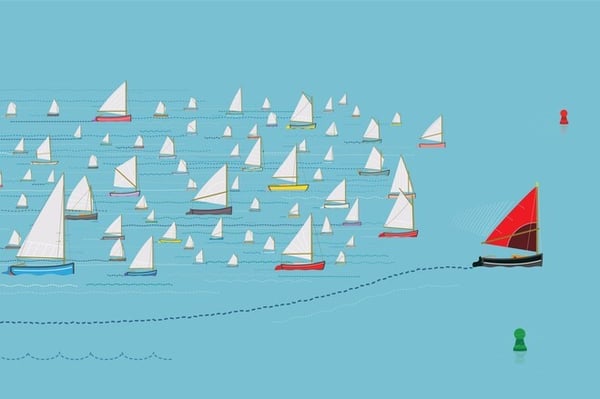 Many sailboats with white sales and a sailboat with a red sail leading the group