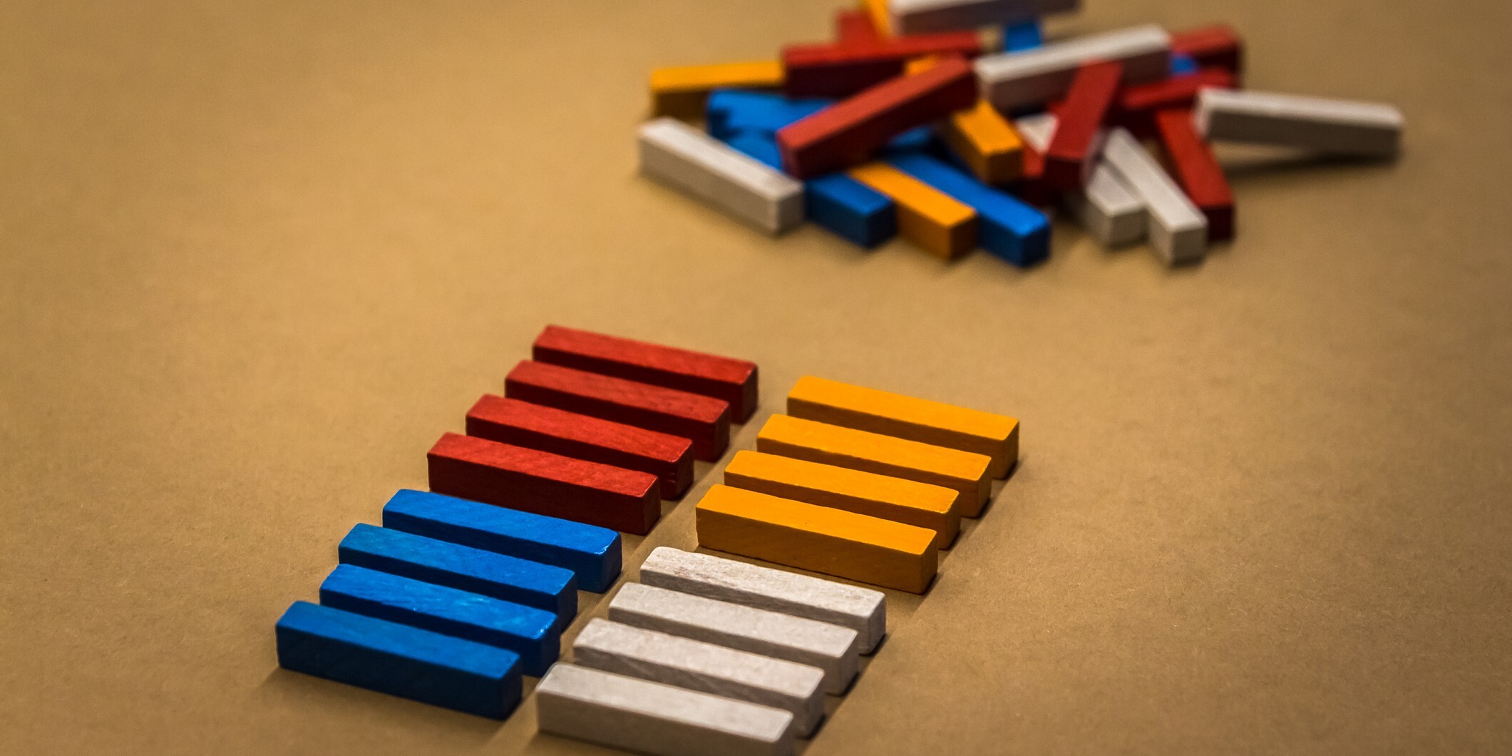 Rectangular, multi-colored blocks lined up in two rows in front of a pile of unorganized blocks