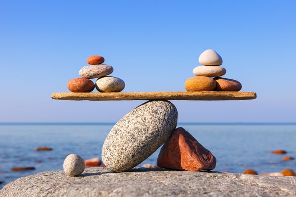 Two beautifully arranged stacked rocks balancing on a flat rock